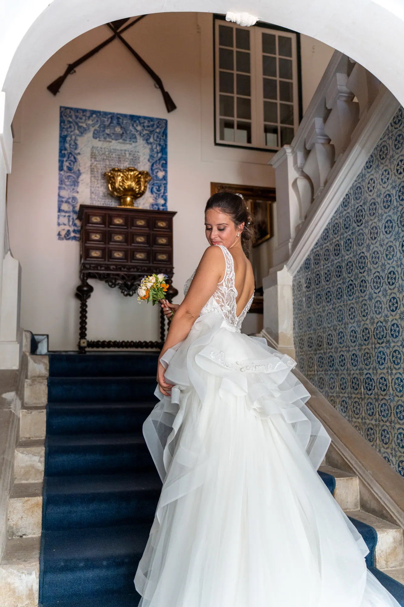 Noiva a descer uma escadaria de azulejos, com o vestido em movimento